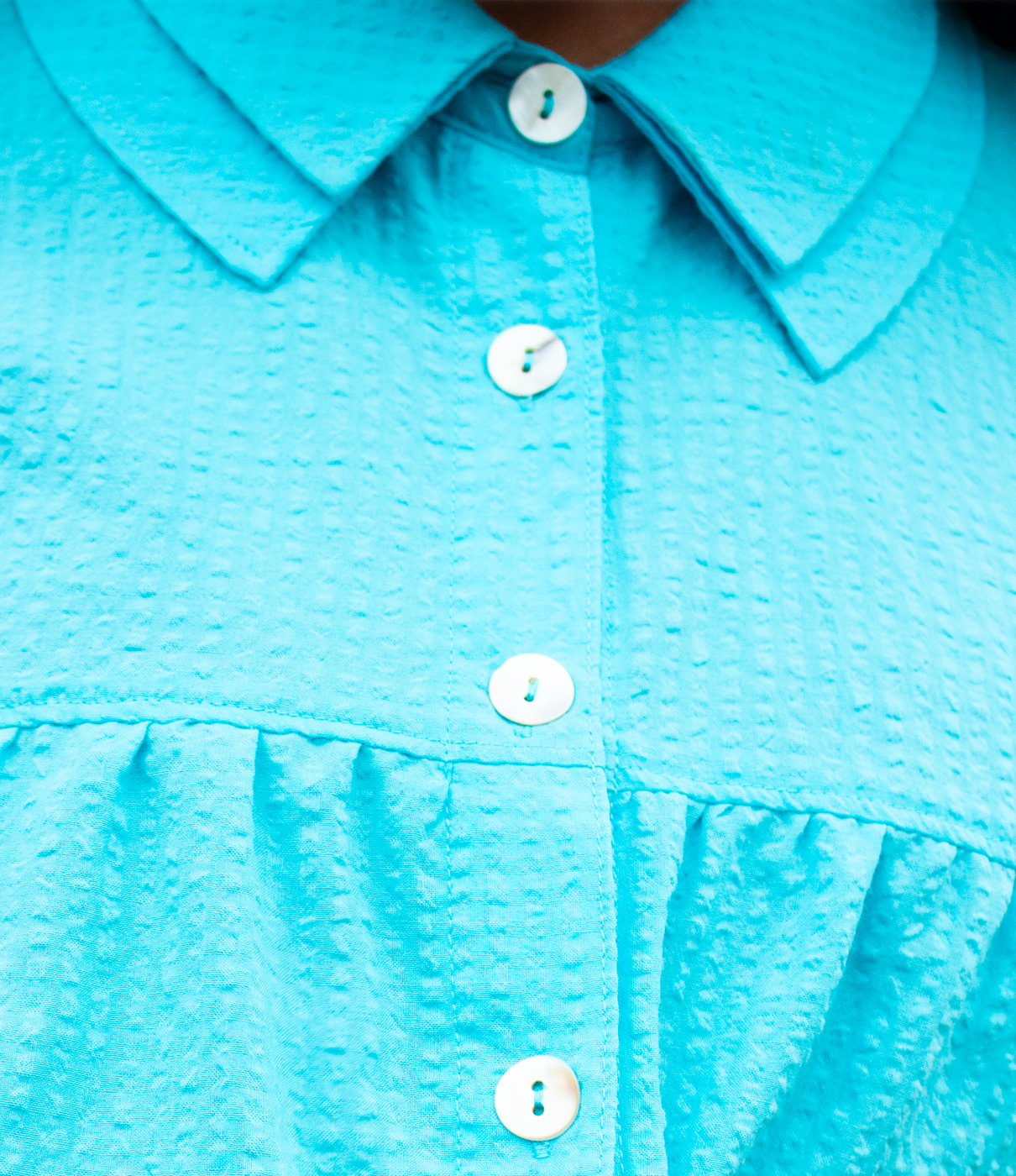 Close-up of a Bright Cerulean blue turquoise shirt with buttons
